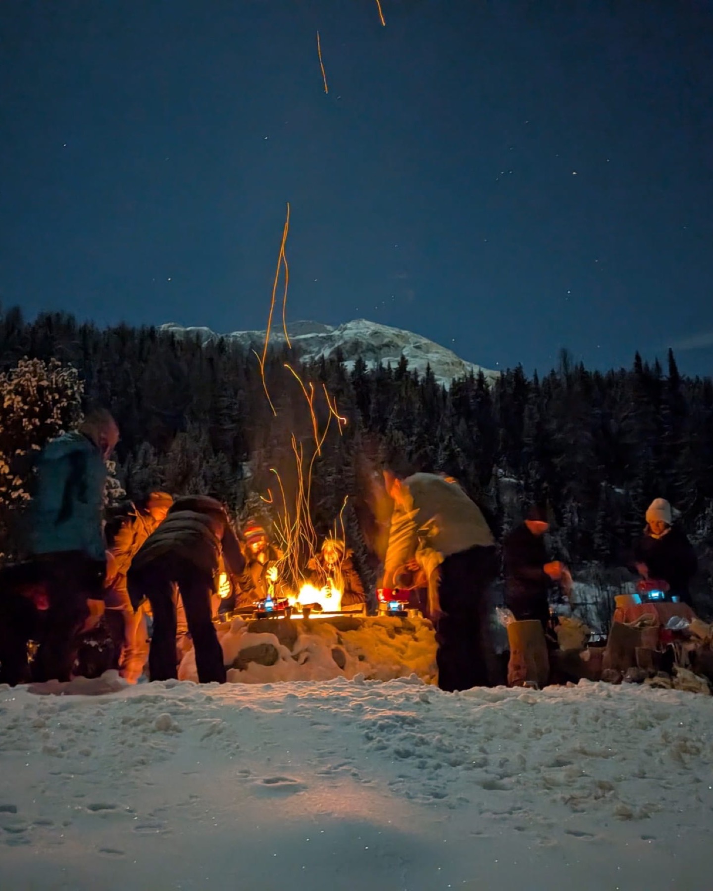 A group gathered around a campfire in the Engadin mountains