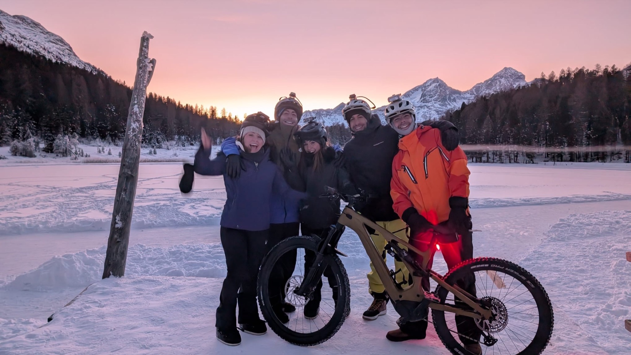 A group on fat-bikes at sunset beside the frozen lake