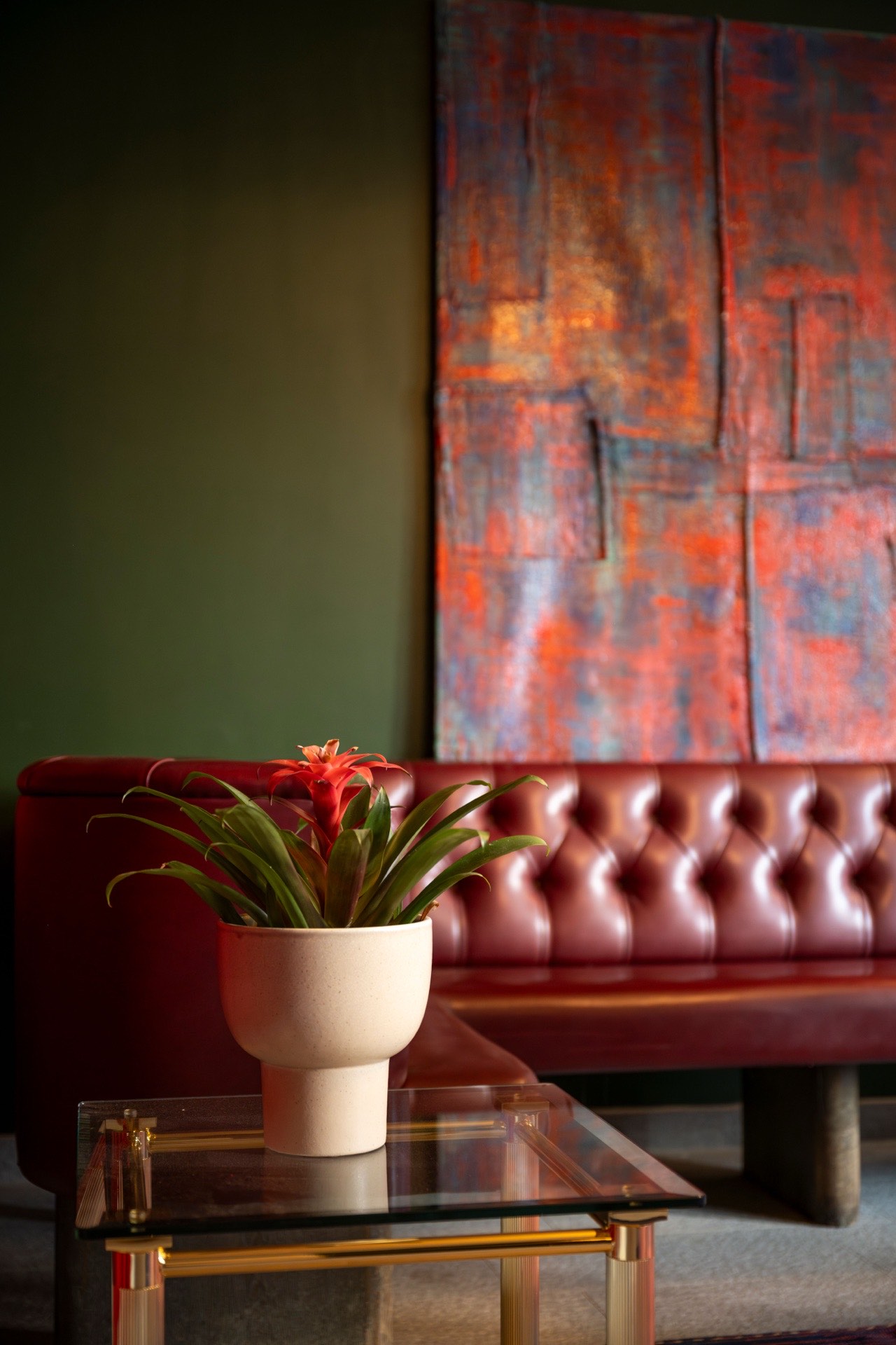 Bromeliad flower against tufted red leather at Le Bar