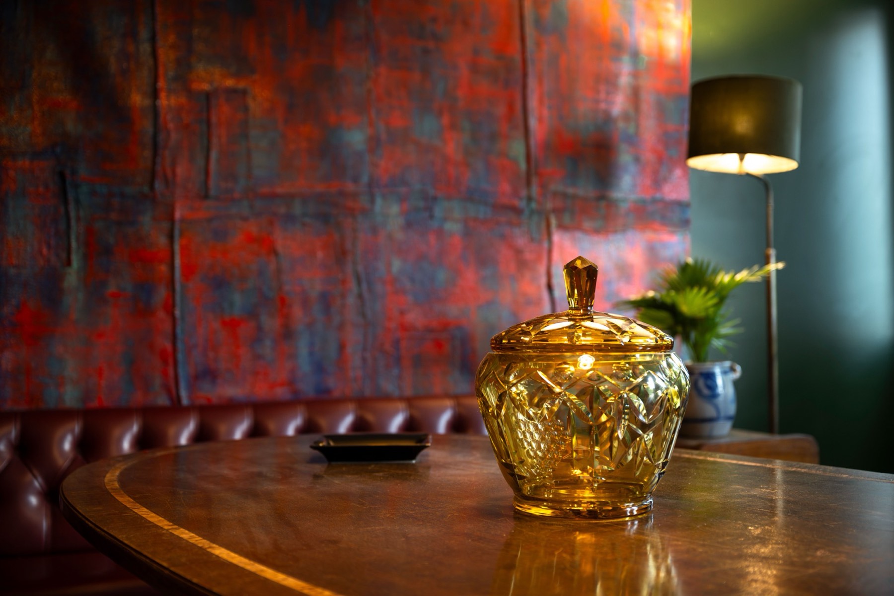 Crystal amber vessel on the oval table at Le Bar